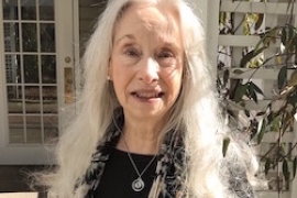 Louise Hawes ’65 standing in front of her home.